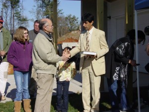 Ed Saulvester prsenting new family with gardening book.